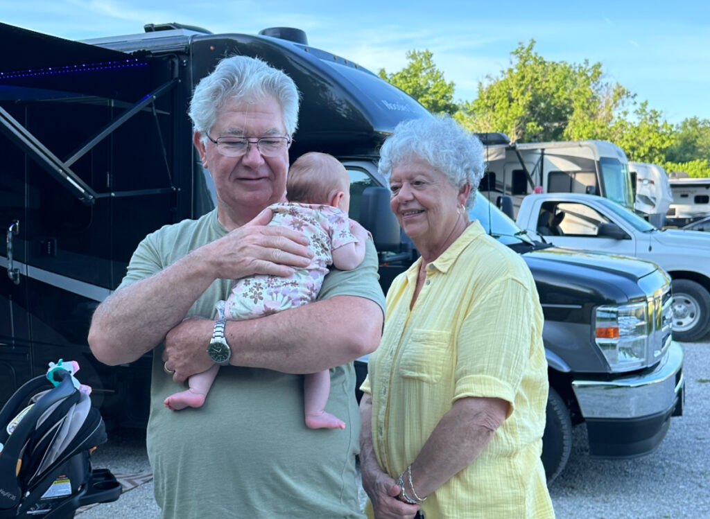 Earl and Pat Robbins meet their great-grandchild outside their Hoosier Custom Cruiser motorhome